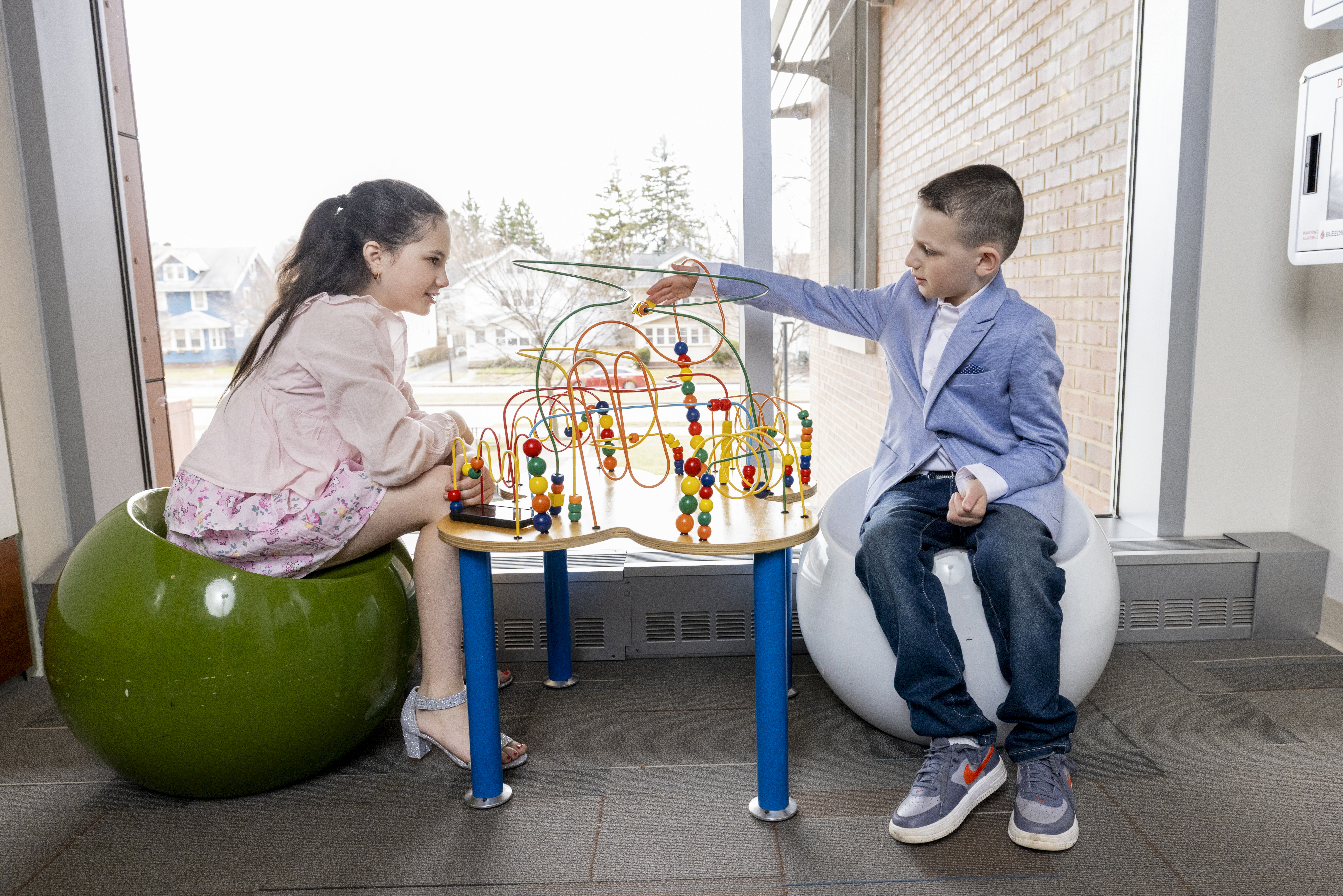 young boy and girl playing with a tabletop toy
