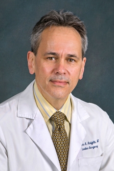 Dr Peter Knight wearing yellow shirt and white coat