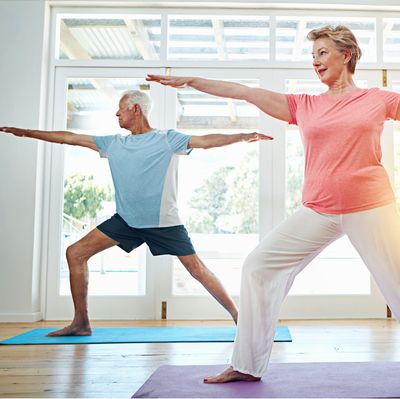 Yoga, stretching and mature couple in home for fitness, health and wellness with warrior pose. Workout, senior man and woman on mat for pilates, balance and body care exercise together in retirement.