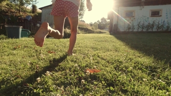 young girl running barefoot in yard at sunset