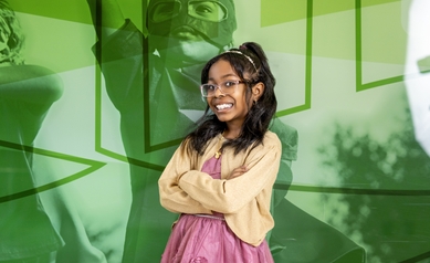 young girl with crossed arms smiling at camera