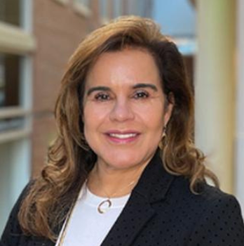 Person smiling at camera wearing white top with dark blazer