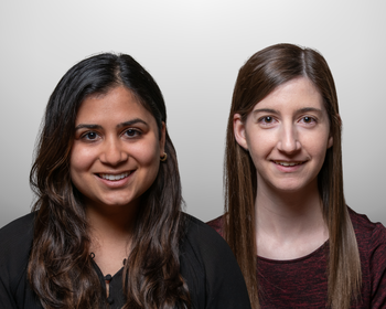 Close-up of two women. The woman on the left has a round face, brown skin, dark eyes, and long wavy dark brown hair. The woman on the left has very light skin, a narrow face, light brown eyes, and long, straight brown hair.