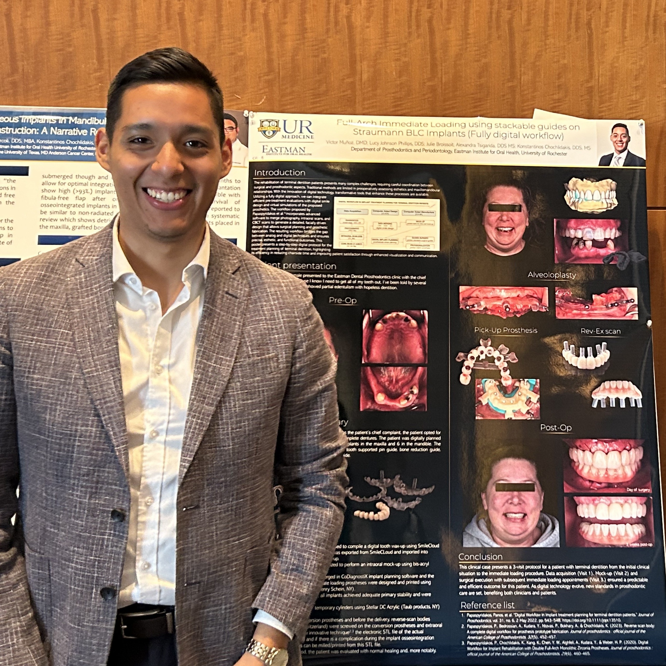 A young man stands in front of a scientific poster featuring many photos and diagrams of mouths and dental implants.