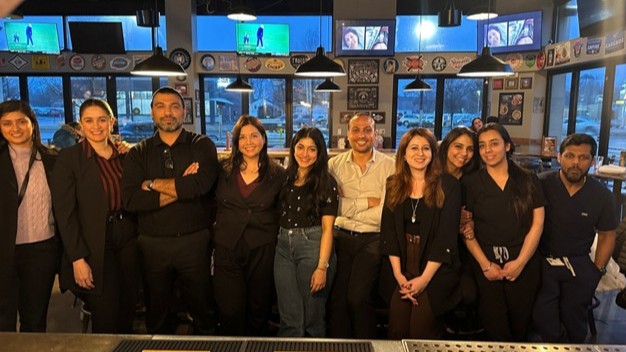 A group of people stand together in a restaurant.