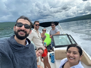 Three men and three women on a small motor-powered boat, which seems to be moving down a river.