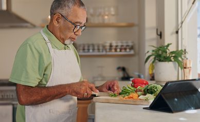 Man slicing vegetables in kitchen.