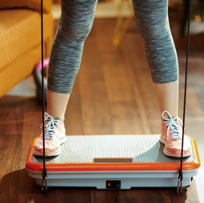 Closeup on sports woman training using vibration power plate