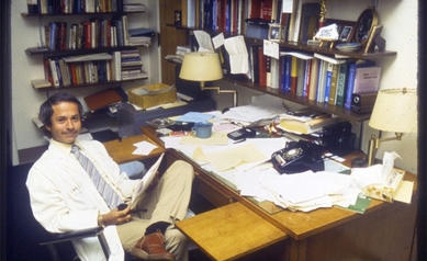 picture of a younger Gary Morrow, next to a messy desk at Wilmot Cancer Institute