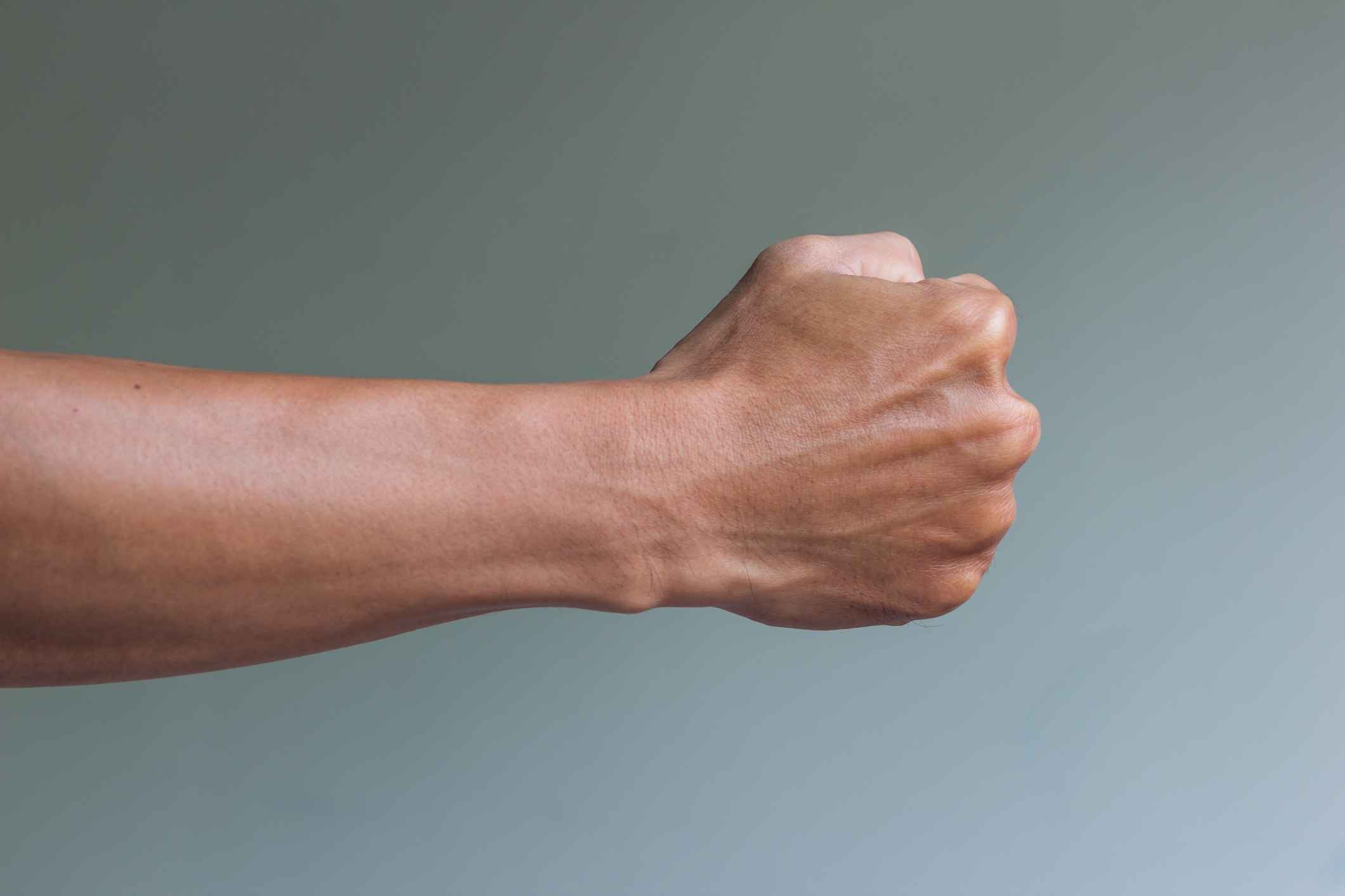 Photo of arm with clenched fist. 