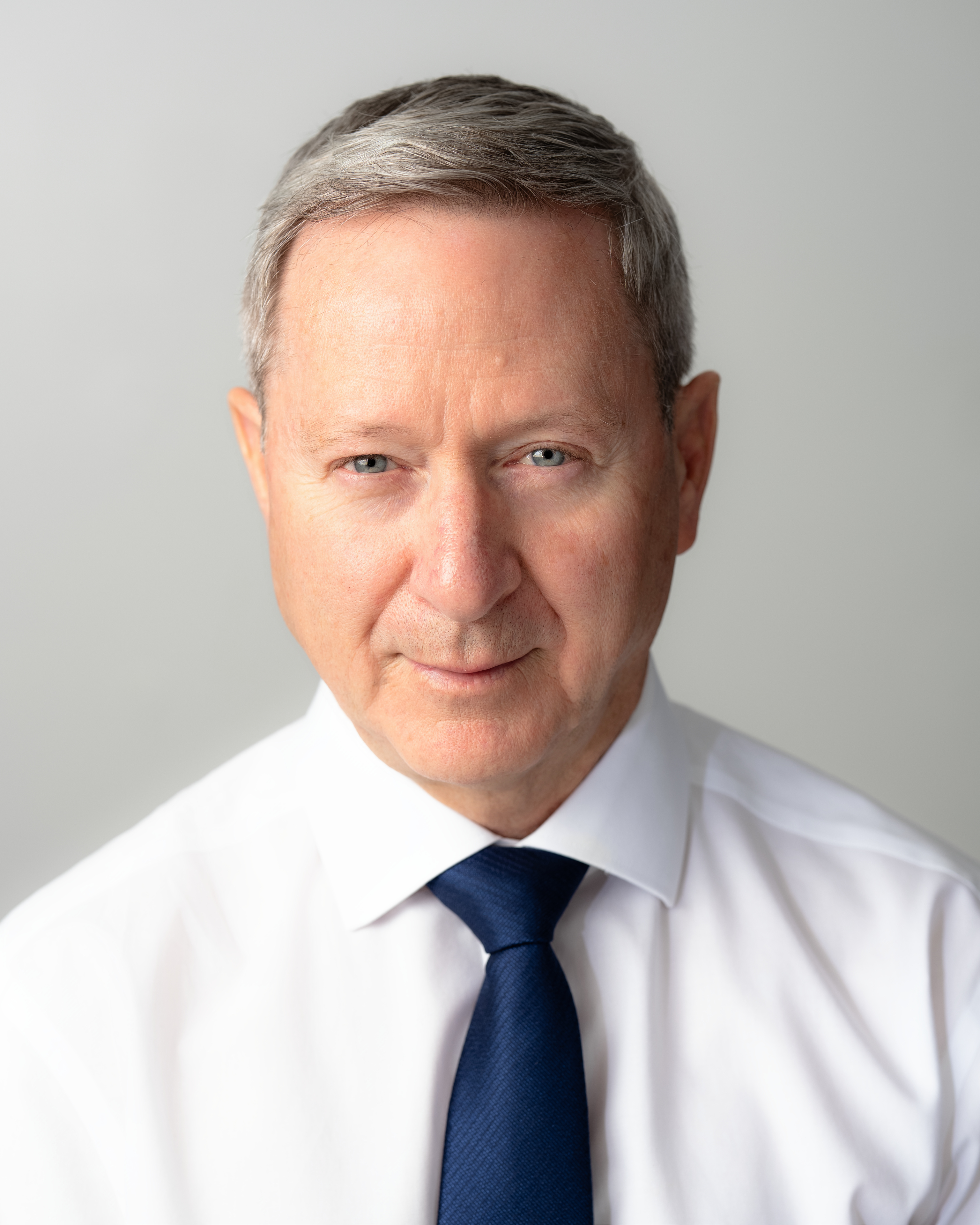 Professional portrait, wearing white shirt and blue tie