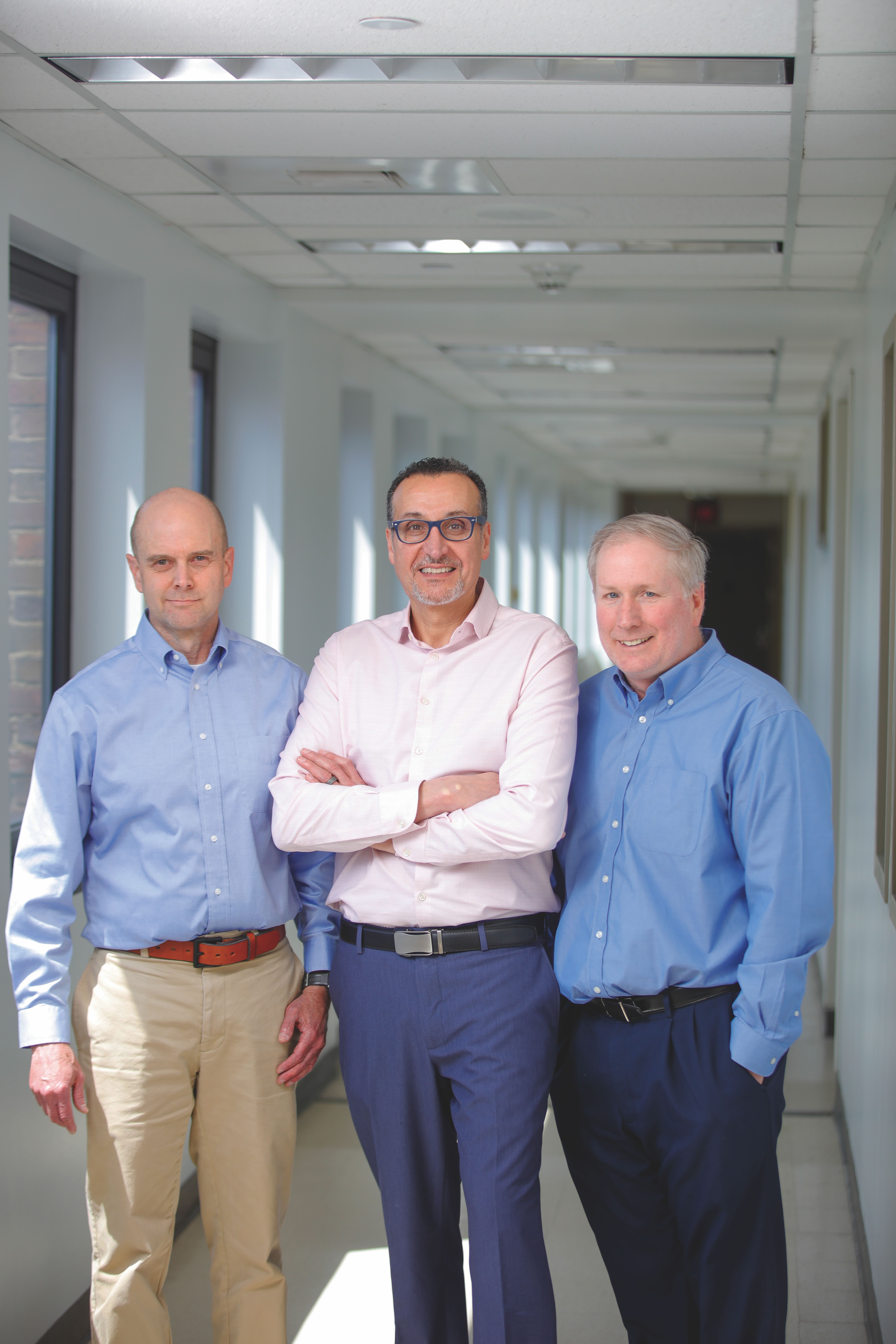 Researchers Ben Miller, Hani Awad, and James McGrath stand next to each other on the Health Sciences campus.
