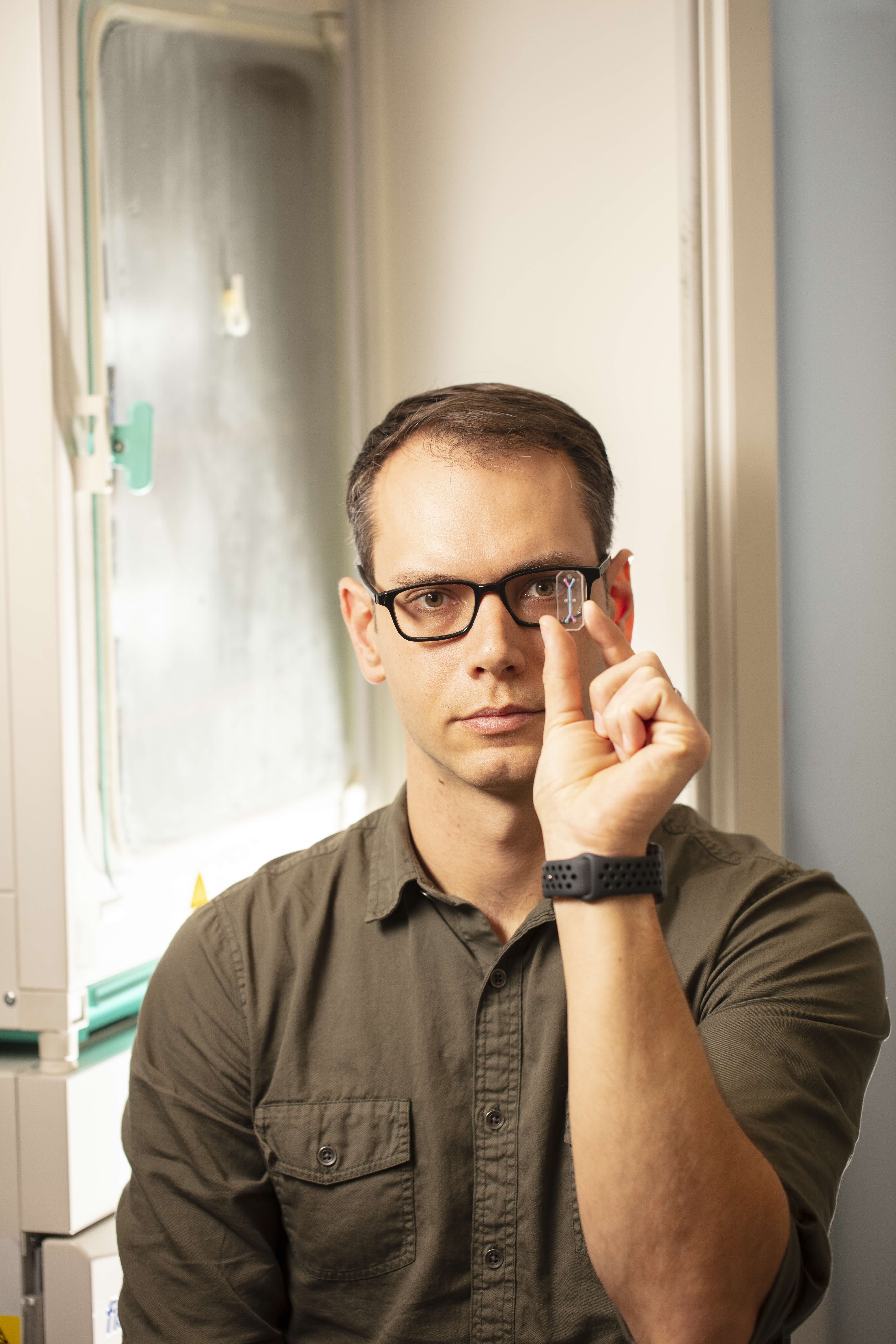 Ben Frisch, PhD, holds a small tissue chip he uses in cancer research.