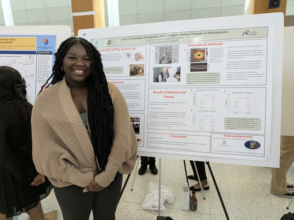 student with poster at scientific presentation