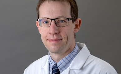 Middle-aged male doctor wearing glasses and a white coat