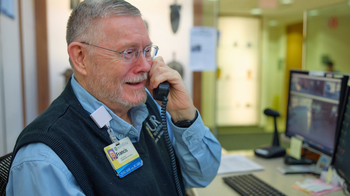 A smiling man speaking on the phone.