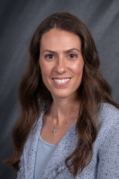 A portrait of a woman with long brown hair.