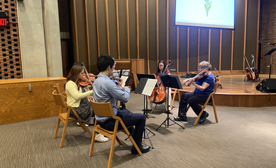group of musicians playing string instruments at a memorial service