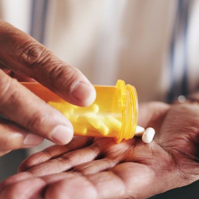 person pouring medication into hand