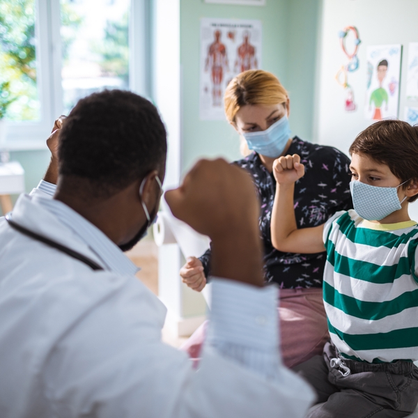 annual child well-visit doctor's office child with mom and doctor diversity pediatrician peds