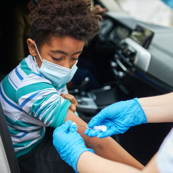 child receives flu shot or COVID vaccine diversity Black