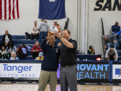 Dr. Al Panu, USCB Chancellor, and Joel Taylor, Novant Health President of the Hilton Head area, hold up a basketball branded with both organizations' logos.