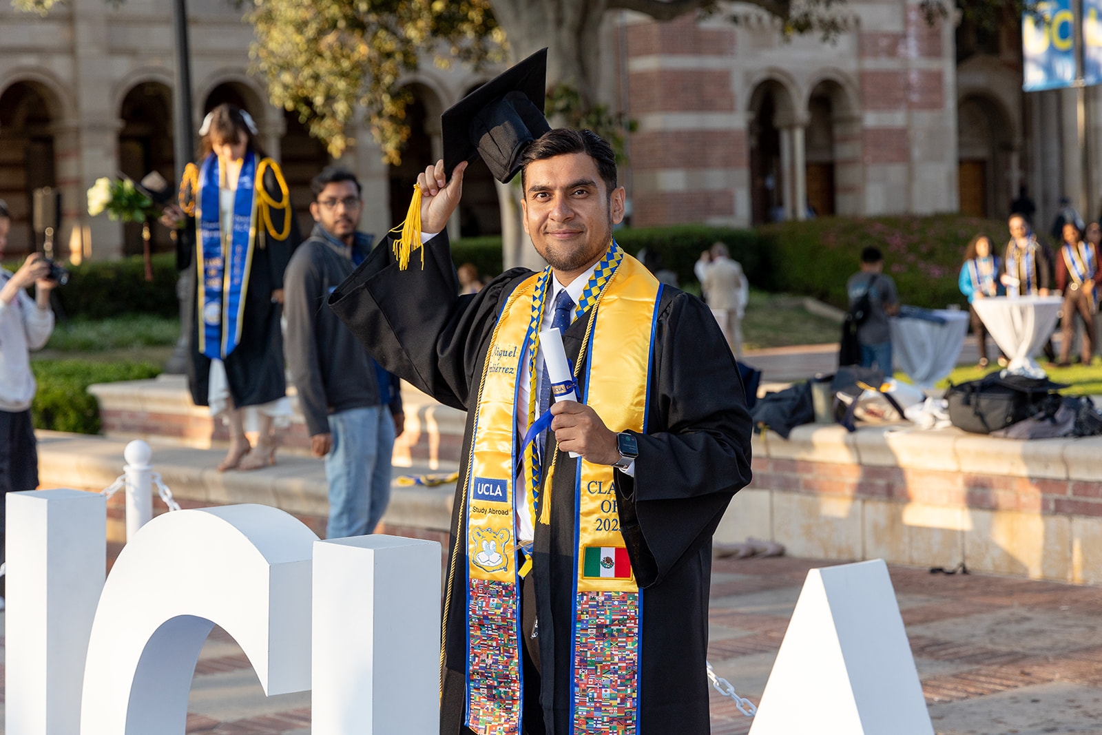 Photo | UCLA Extension Graduate in grad attire holding cap and certificate. | UCLA Extension Photo | UCLA Extension Graduate in grad attire holding cap and certificate. | UCLA Extension
