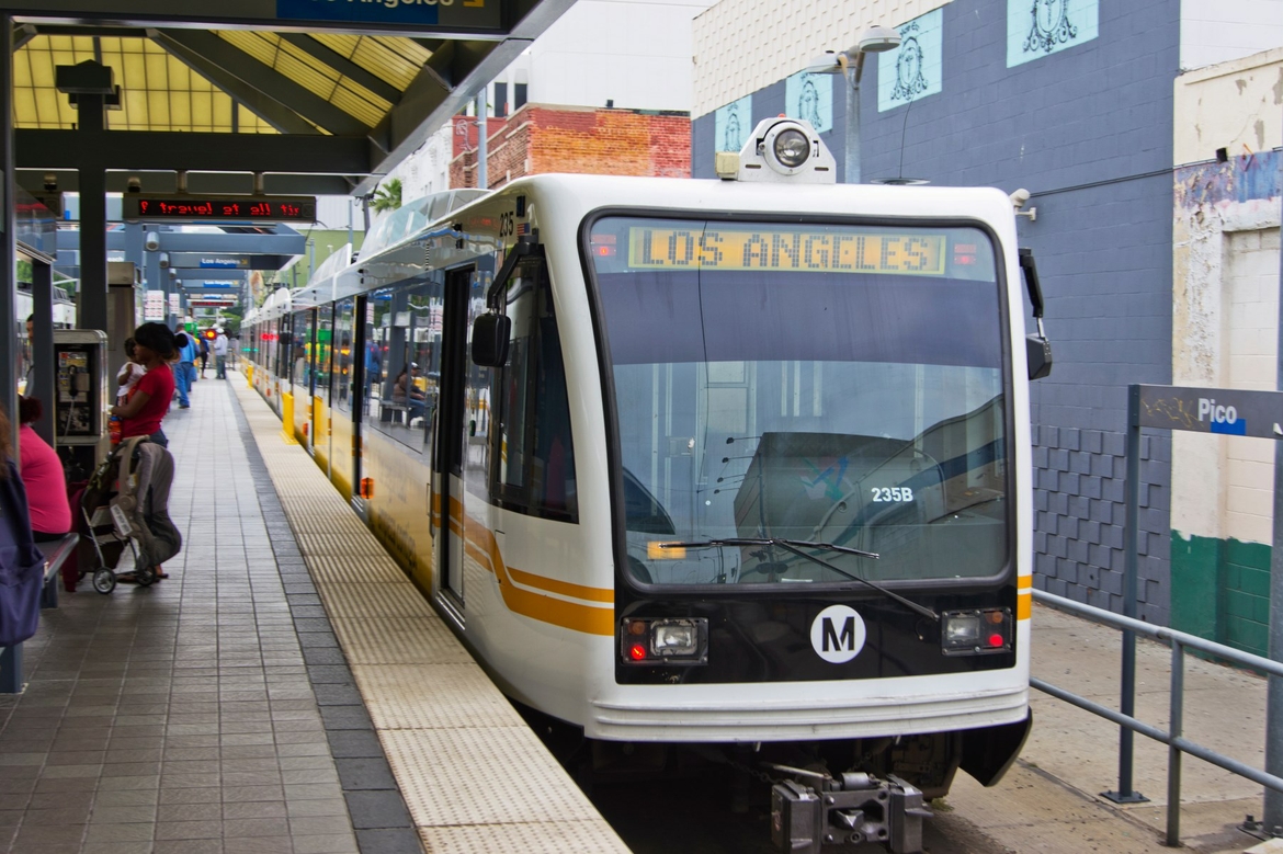 Metro Train pulling forward to a stop at train station.