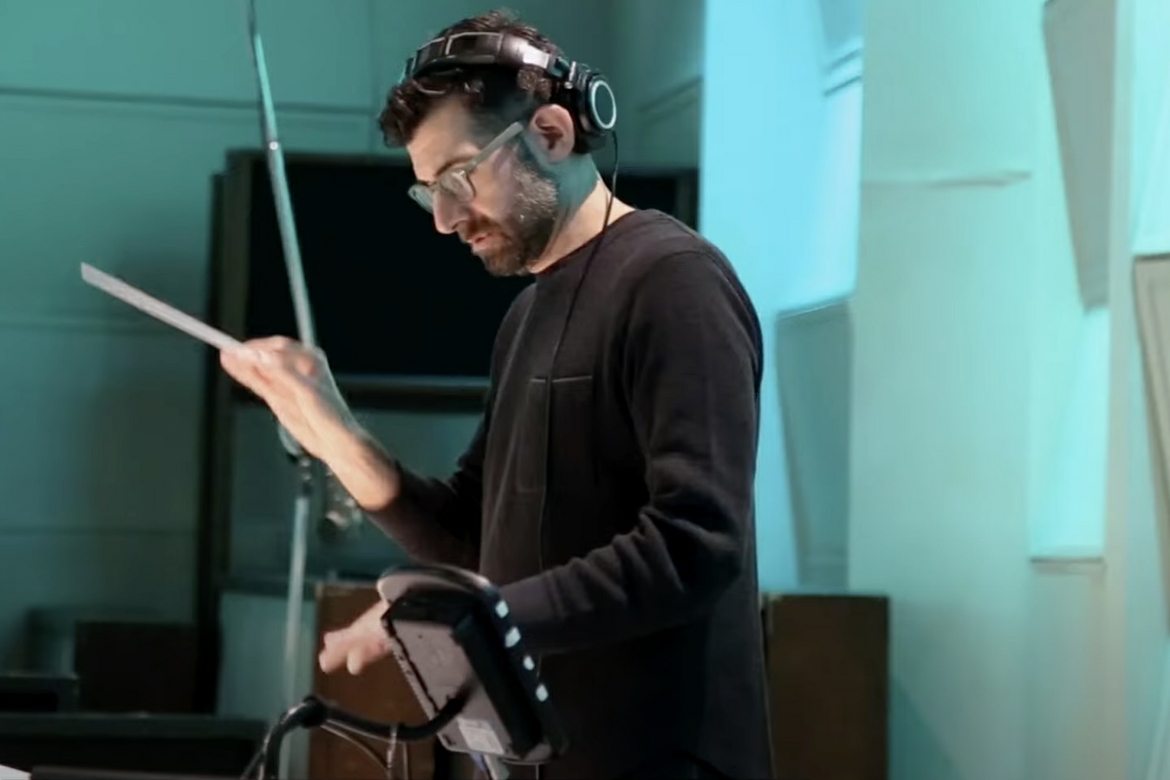 Musical conductor standing in a recording studio/room.