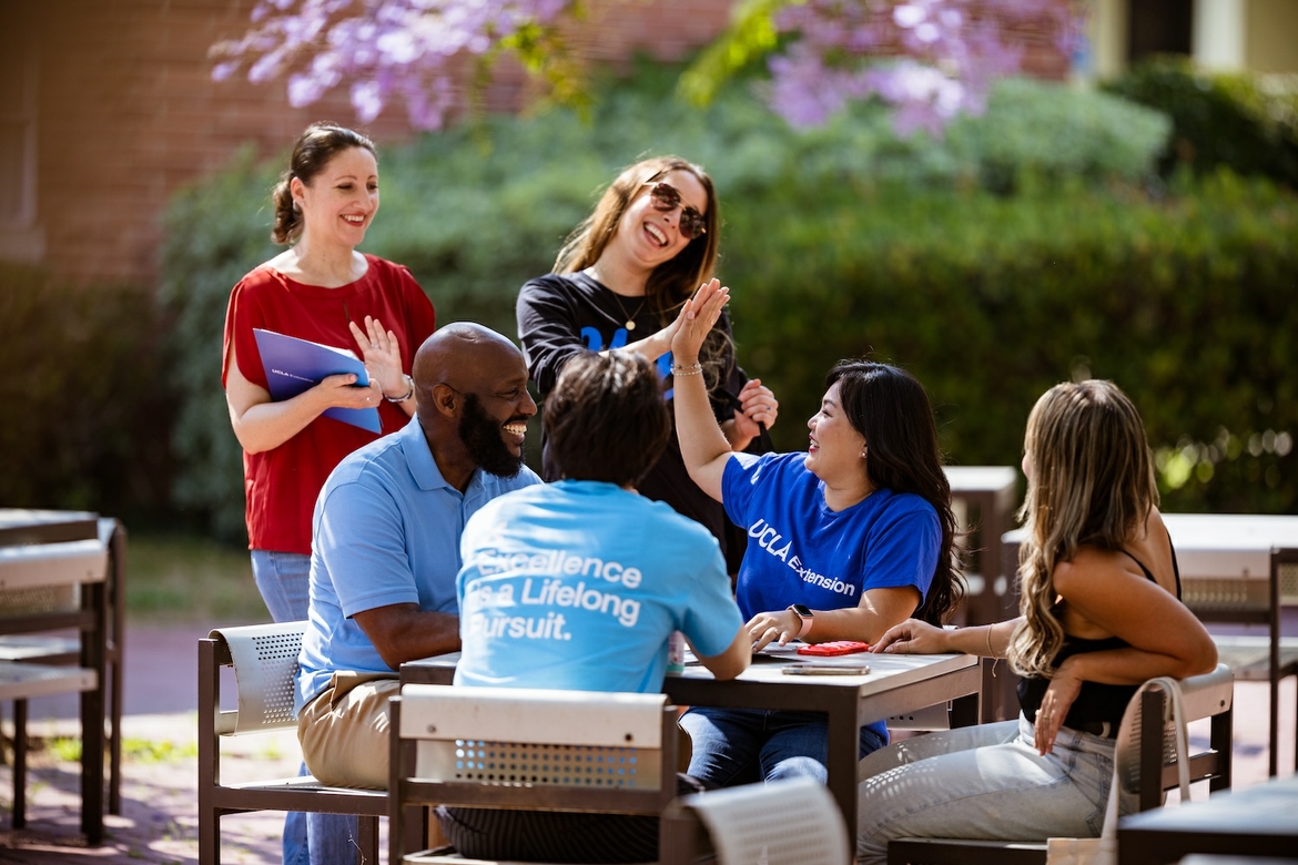 UCLA Extension workers are sitting together outside.