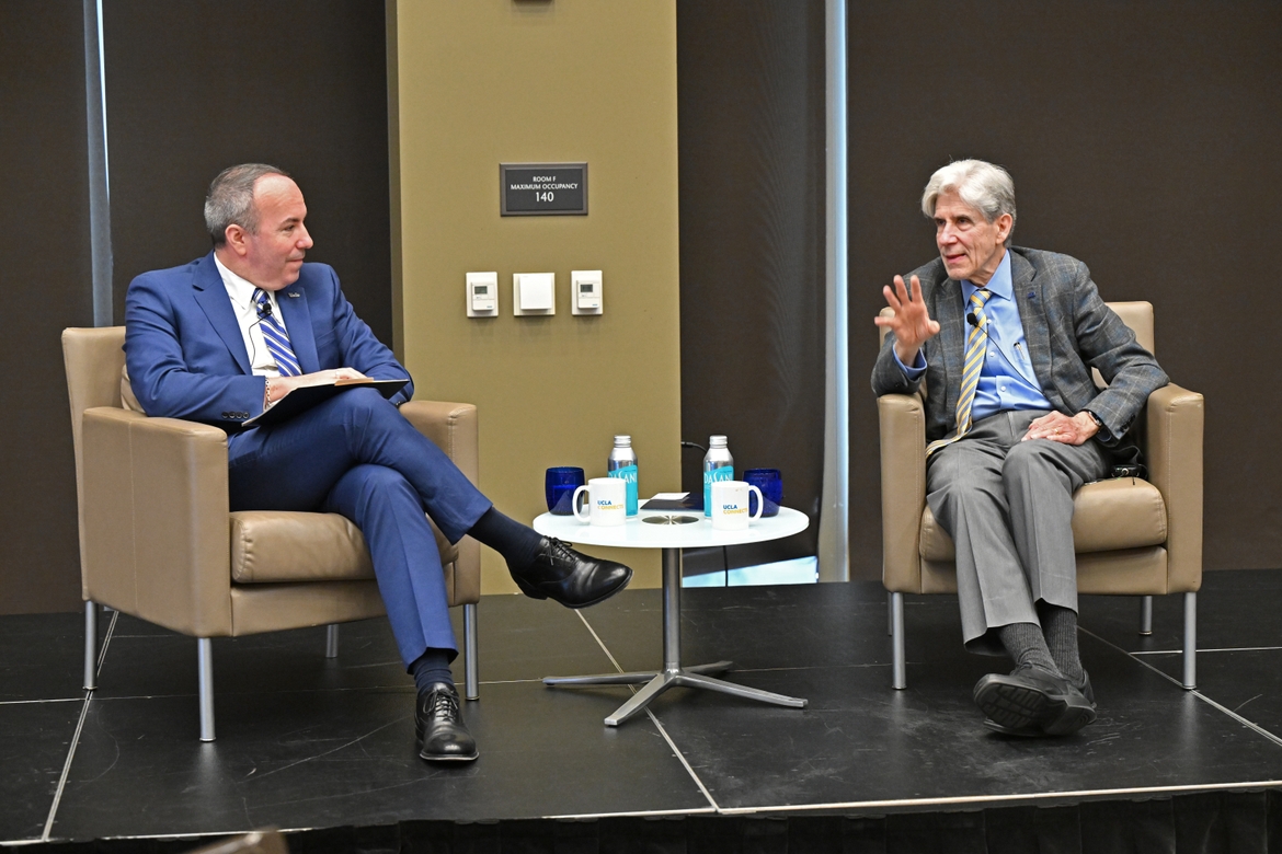 Julio Frenk and Dean Eric Bullard speaking to each other.