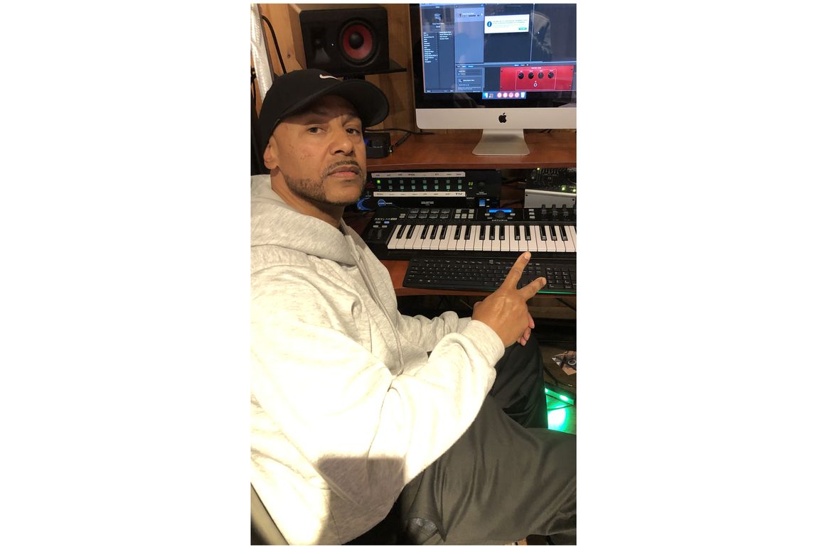 William Riley in front of music system while creating music.