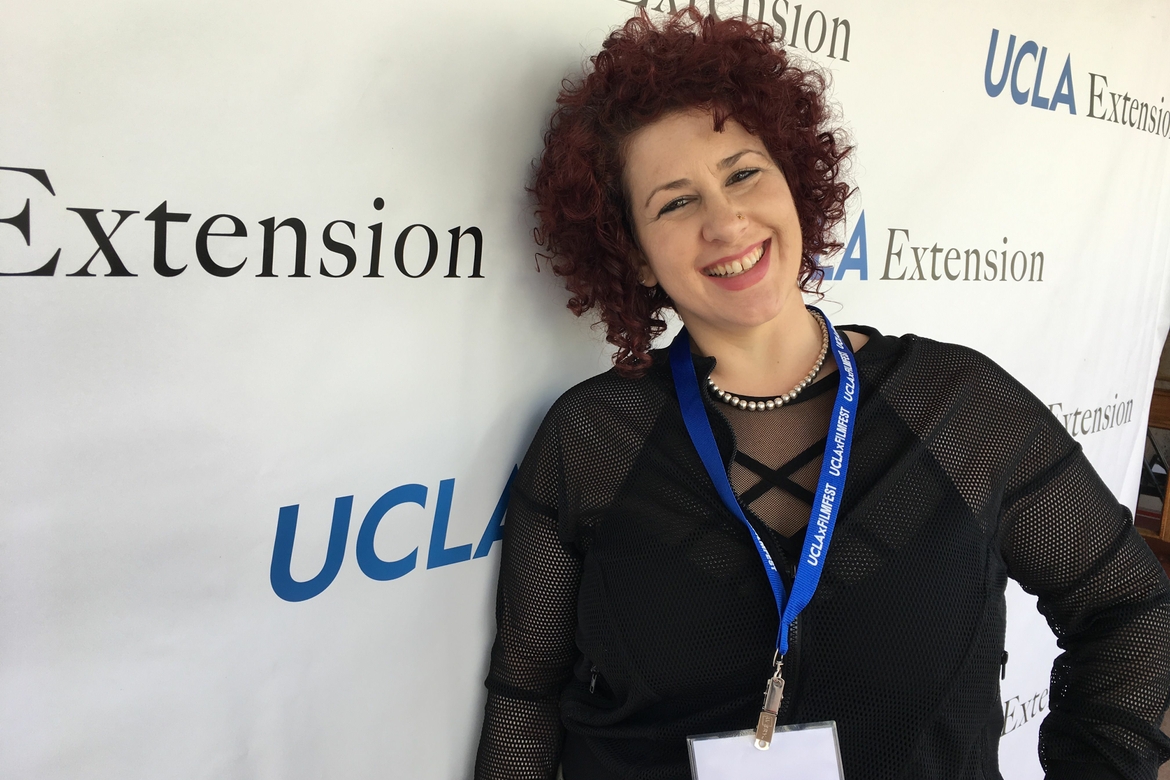 UCLA Alumna Rosa Costanza smiling in front of UCLA Extension backdrop.