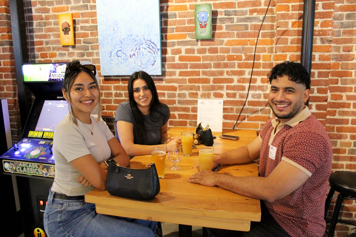 Three UCLA Extension Alumni enjoy a drink at a table top