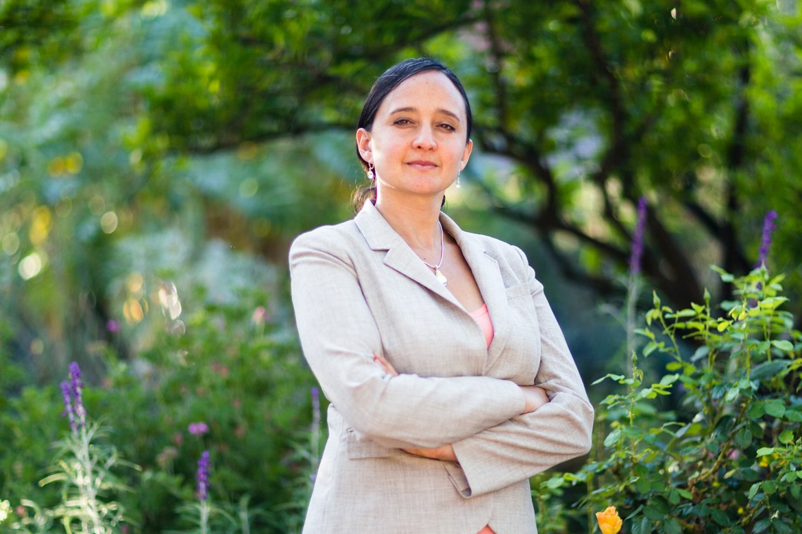 Nurit Katz posing for a picture in front of greenery