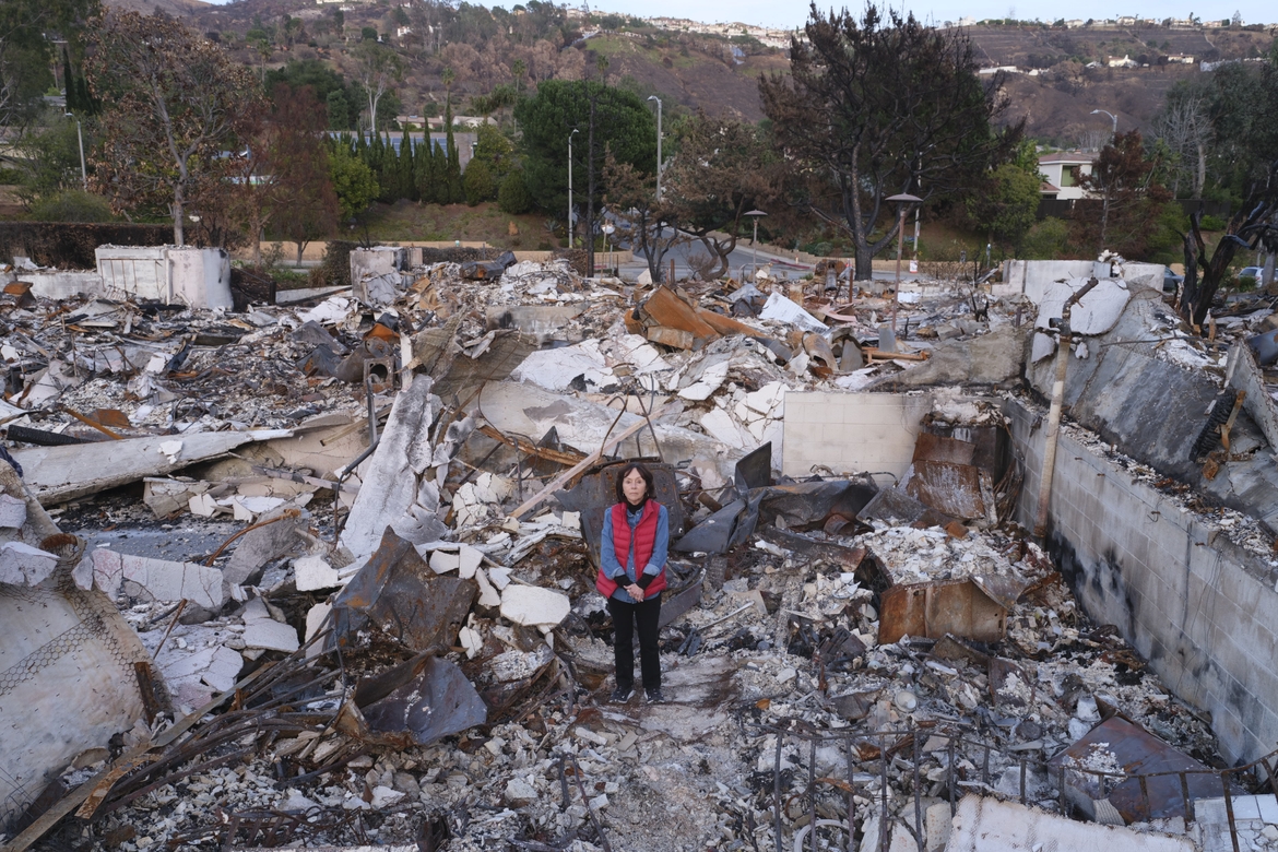 Nancy Spiller surrounded by the rubble of her home