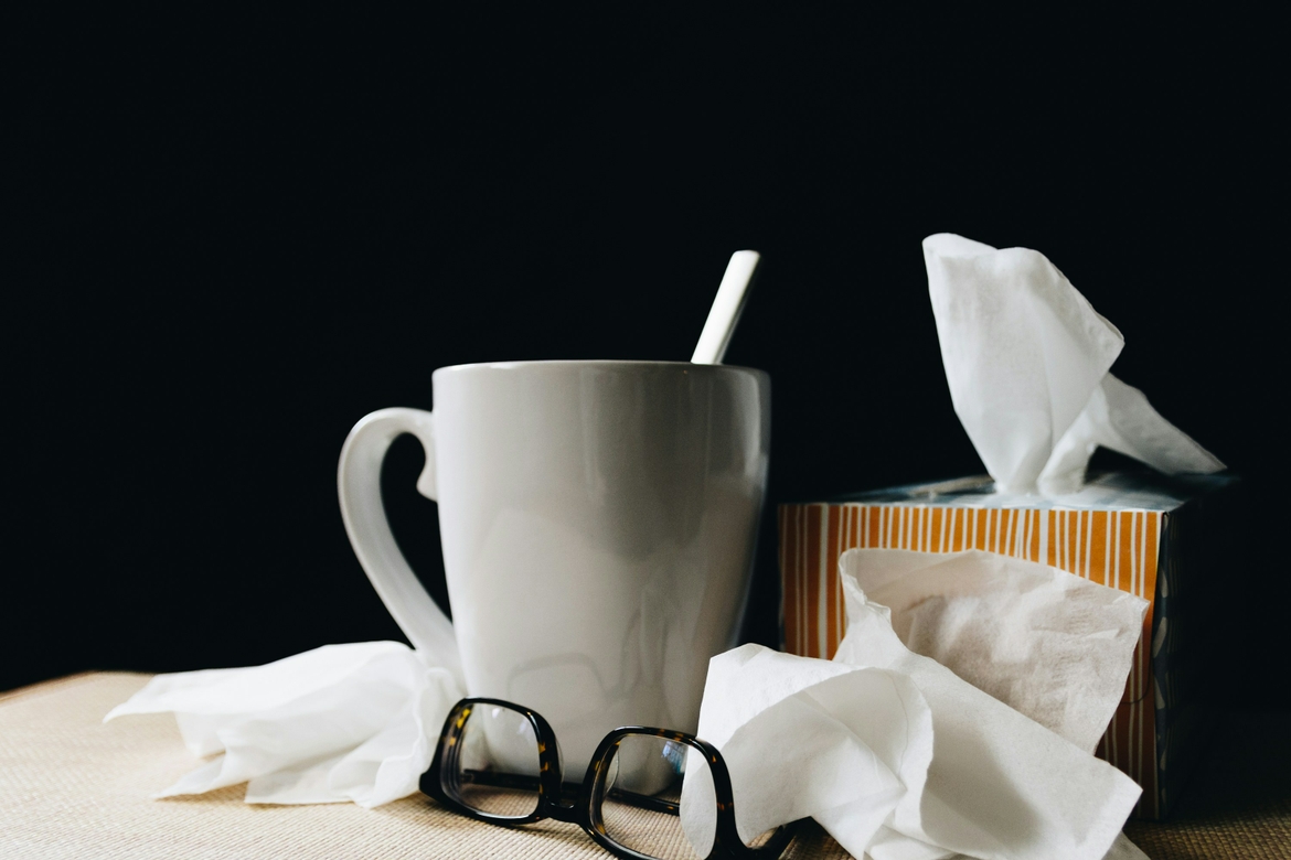 A mug, glasses, tissue box and tissue all strewn about