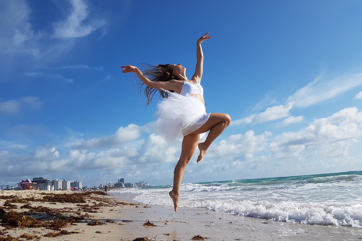 Angel Hass performs a dance move on the beach