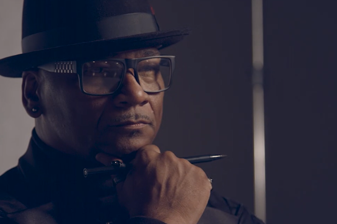 Close up of Roosevelt Brown holding a pen resting on his chin