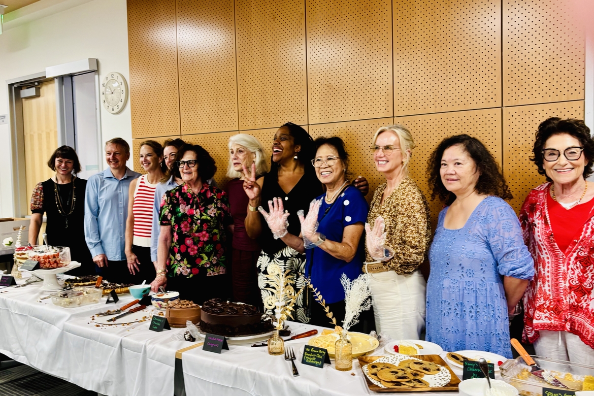 OLLI members and UCLA Extension staff pose behind all their home baked desserts