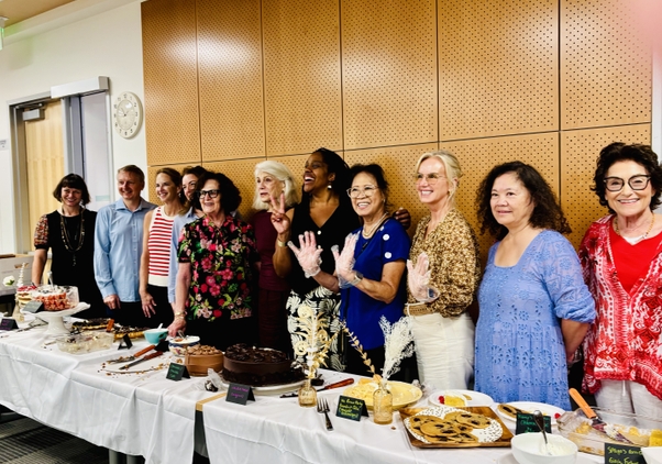 OLLI members and UCLA Extension staff pose behind all their home baked desserts