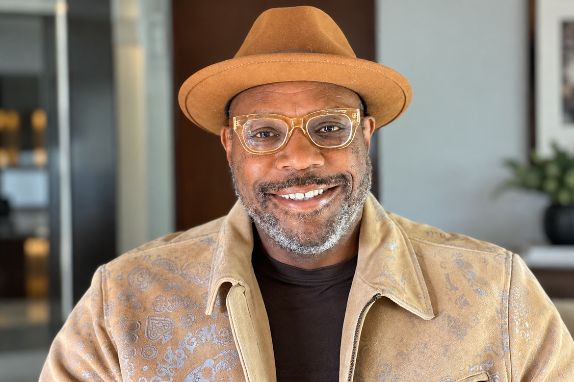 Andre Hardy in a brimmed hat, glasses and coat