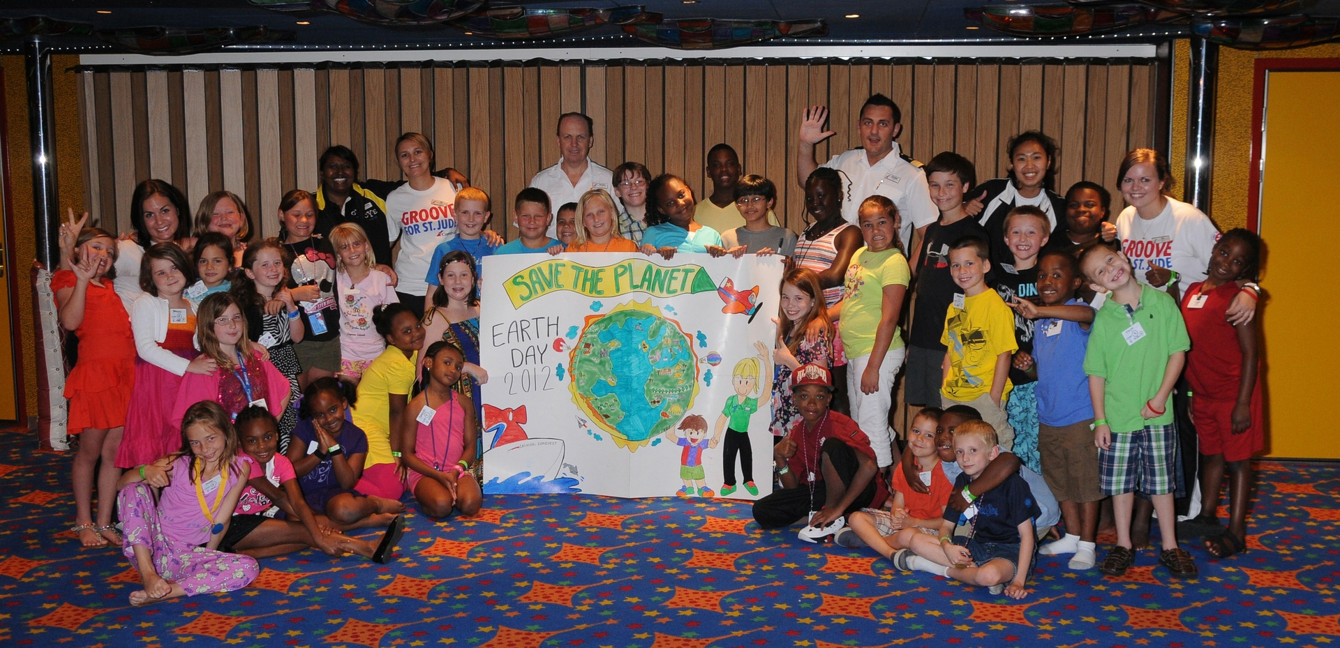 Kids participating in Camp Carnival on the Carnival Conquest show off their Earth Day Poster.