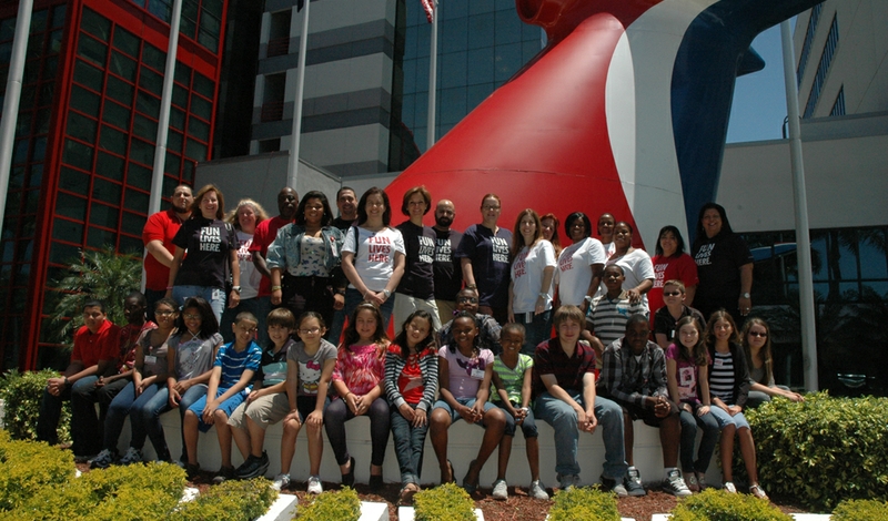 Parents and kids took time during the day for a group picture infront  of Carnival Cruise Lines' funnel located outside its Miami headquarters.