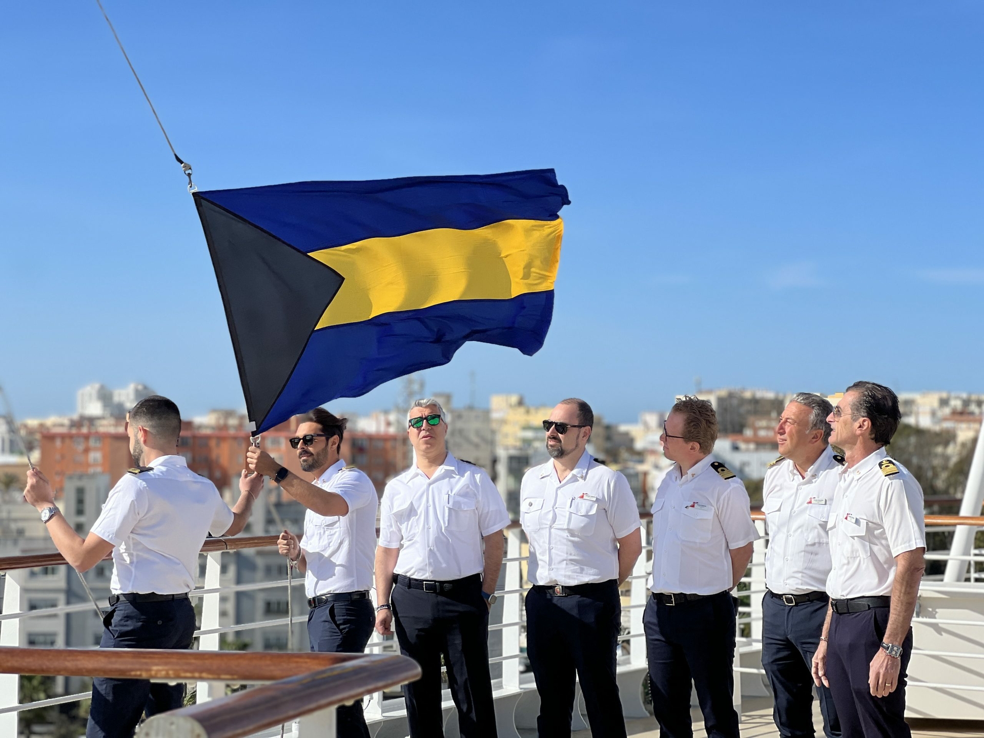 Carnival Venezia officers prepare to raise Bahamian flag