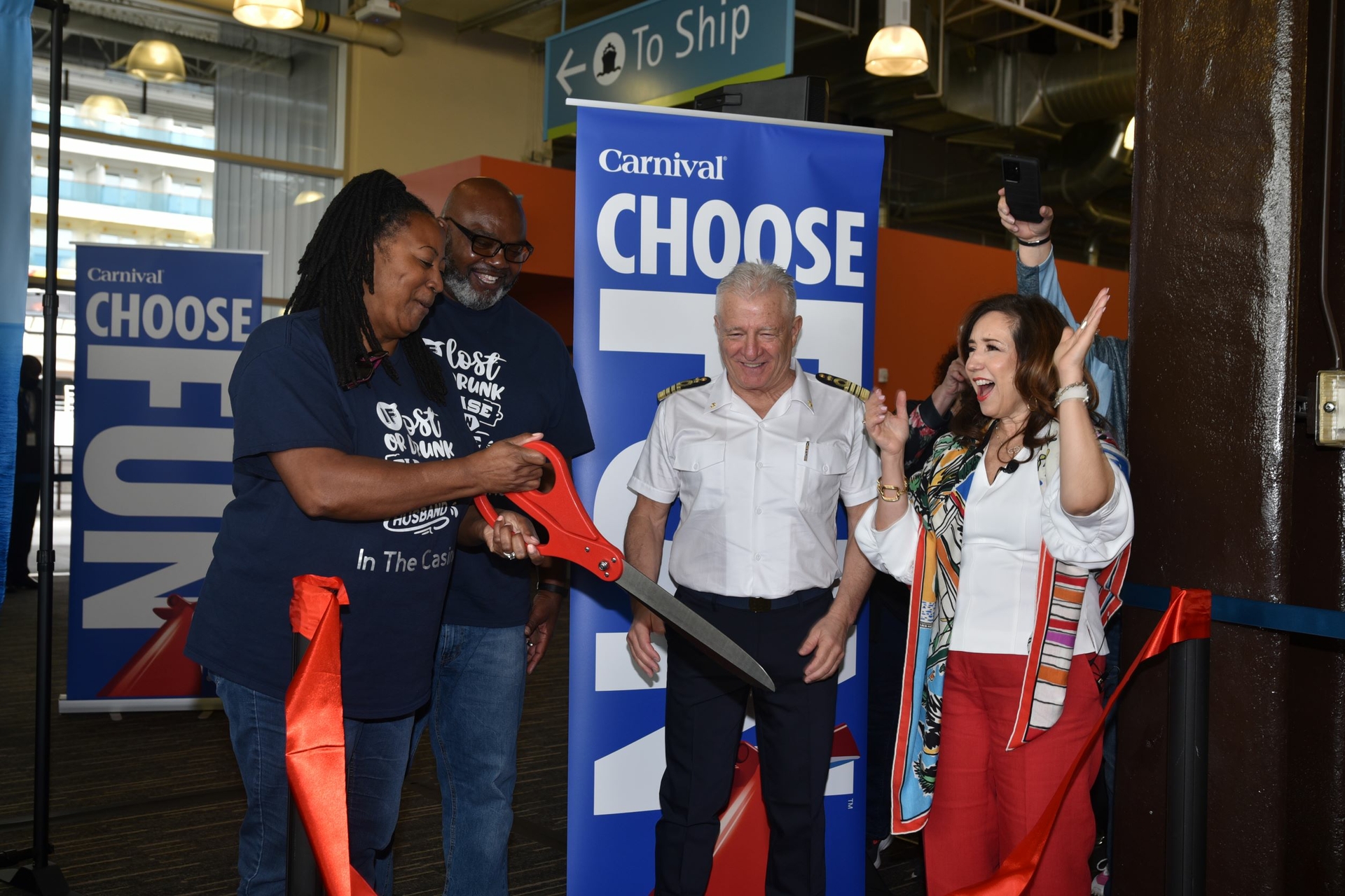 A ceremonial ribbon is cut by guests before embarking on Carnival Luminosa