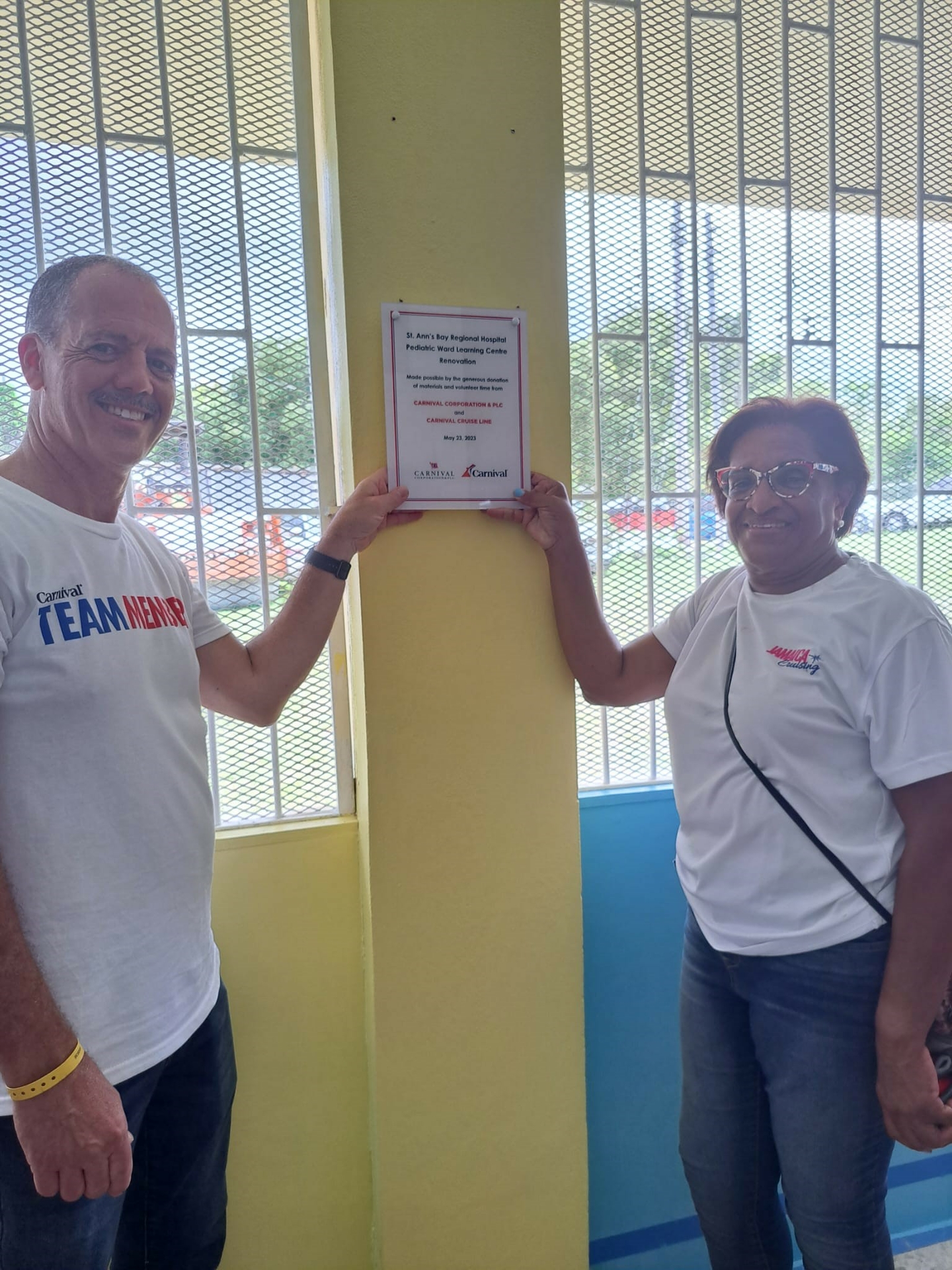 Carnival crew members pose with plaque