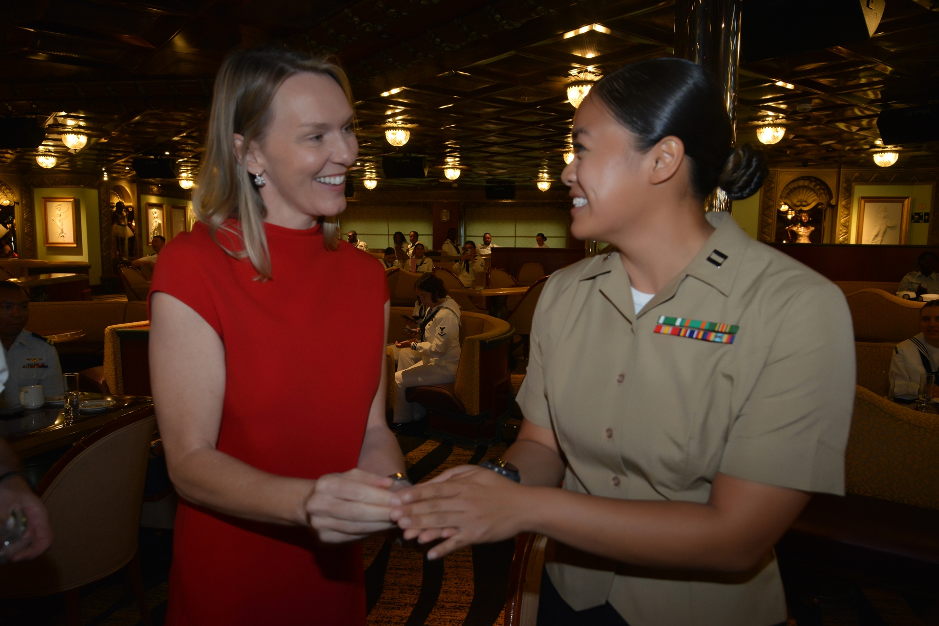 Navy veteran Vera Lannek vice president of strategic sourcing for Carnival Corporation shares a commemorative coin with a service member
