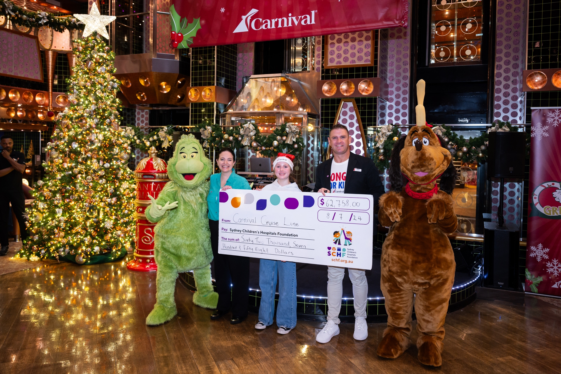 Carnival presenting a cheque to the SCHF - L-R The Grinch SCHF CMO Kate Ferguson Carnival Splendor Goddaughter Matilda Jenkins Carnival Splendor Cruise Director Simon London Max
