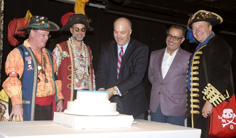 Carnival Chief Communications Officer Chris Chiames and Port Tampa Bay Executive Vice President Raul Alfonso join local Gasparilla pirates to cut 30th anniversary cake
